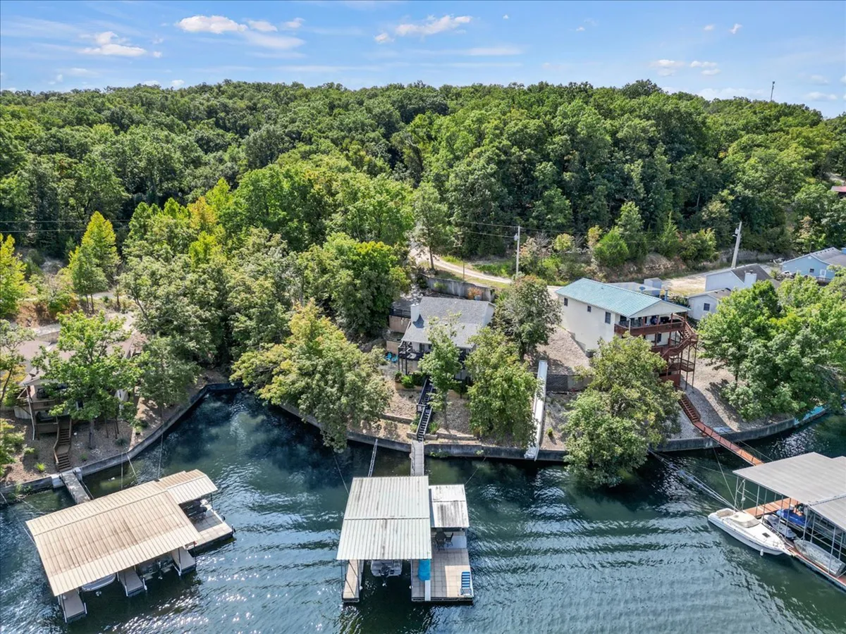 A wide-angle view of houses lining the shoreline, docks stretching into the water, and lush greenery surrounding the area. The tranquil waterway offers a sense of adventure and opportunity for boating or picnicking.