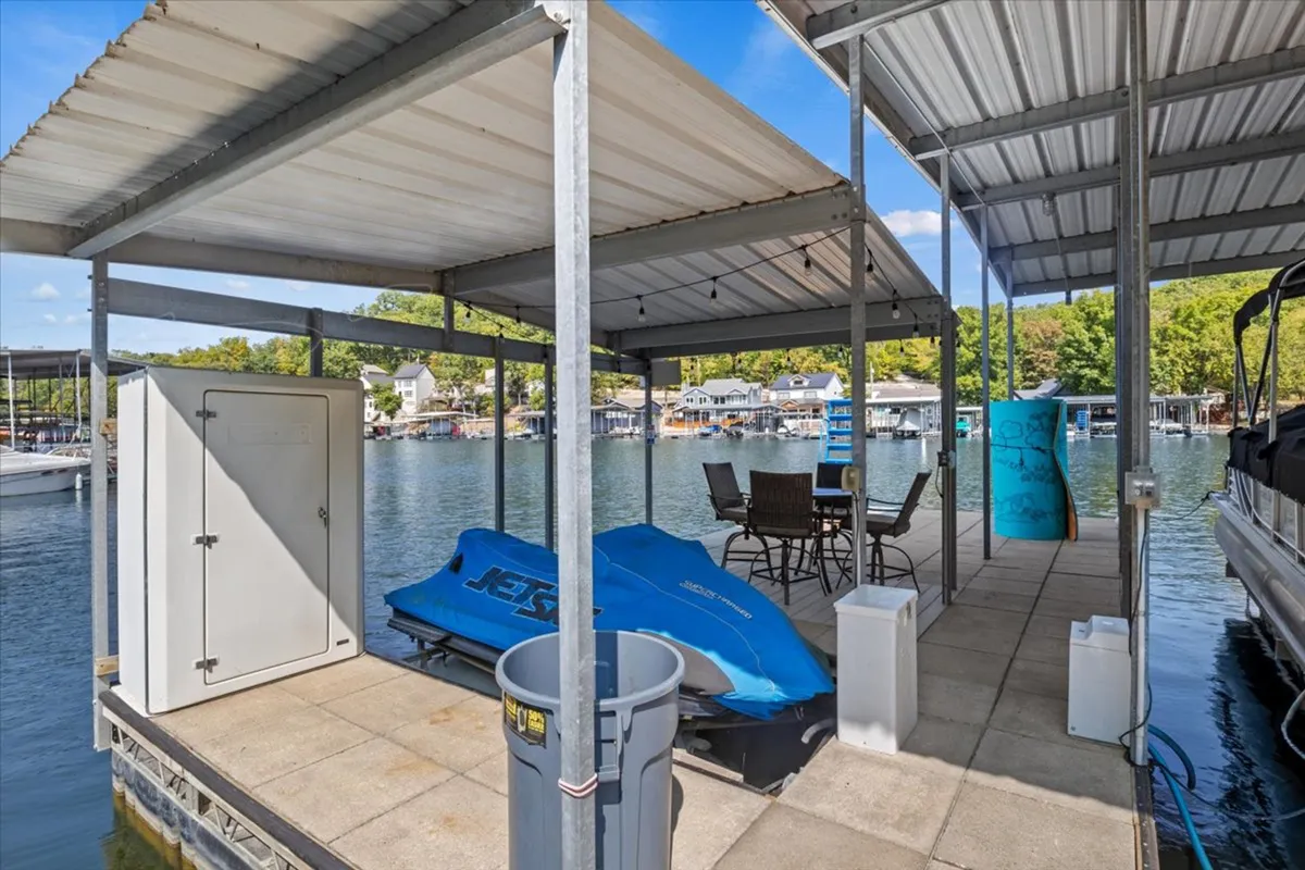A lively lakeside dock scene featuring a dining table, water views, and a jet ski at the ready. The image reflects both relaxation and active fun, illustrating opportunities for boating, friendly competitions, and waterfront socializing.